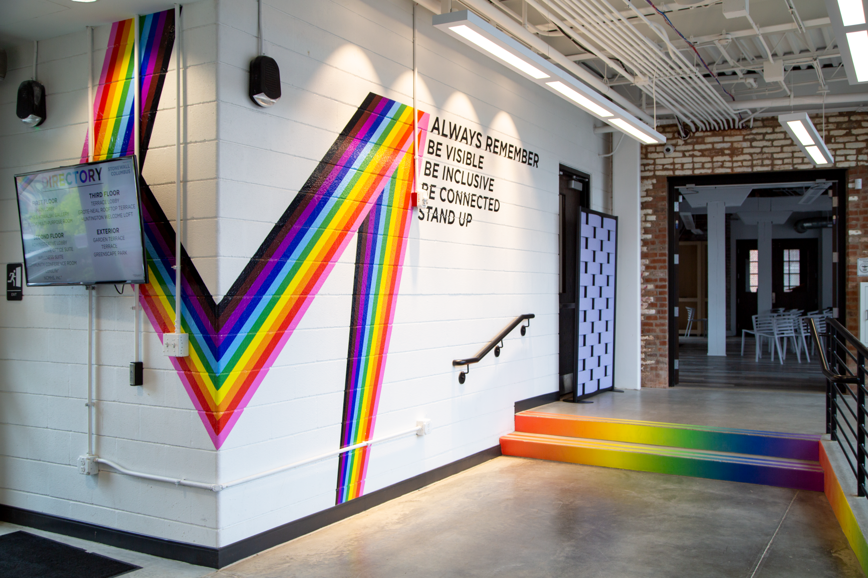 The front entry features a rainbow vinyl graphic that helps bring this space to life at Stonewall Columbus Community Center by Continental Office Branding