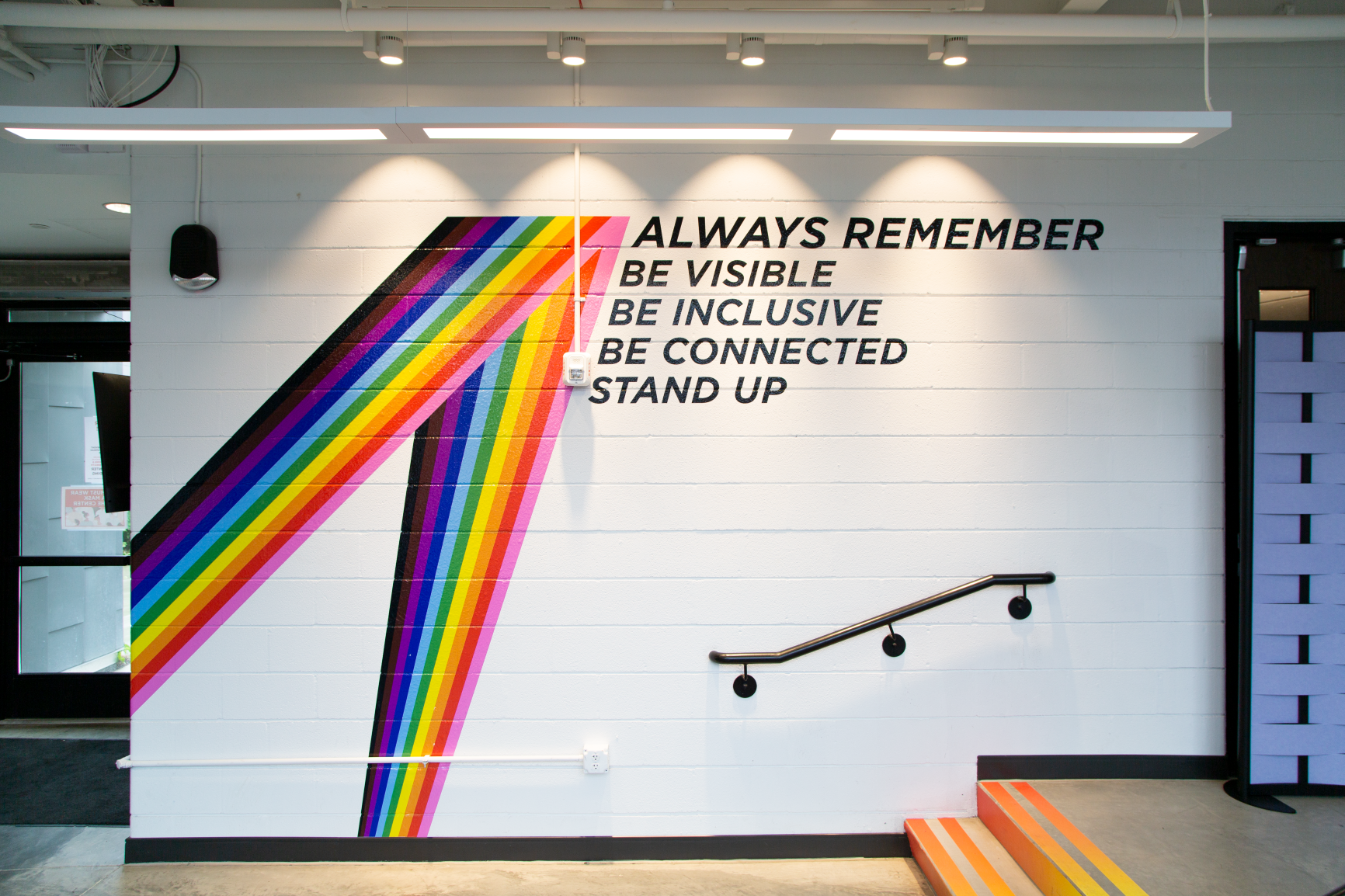 A rainbow vinyl graphic brings this space to life at Stonewall Columbus Community Center by Continental Office Branding