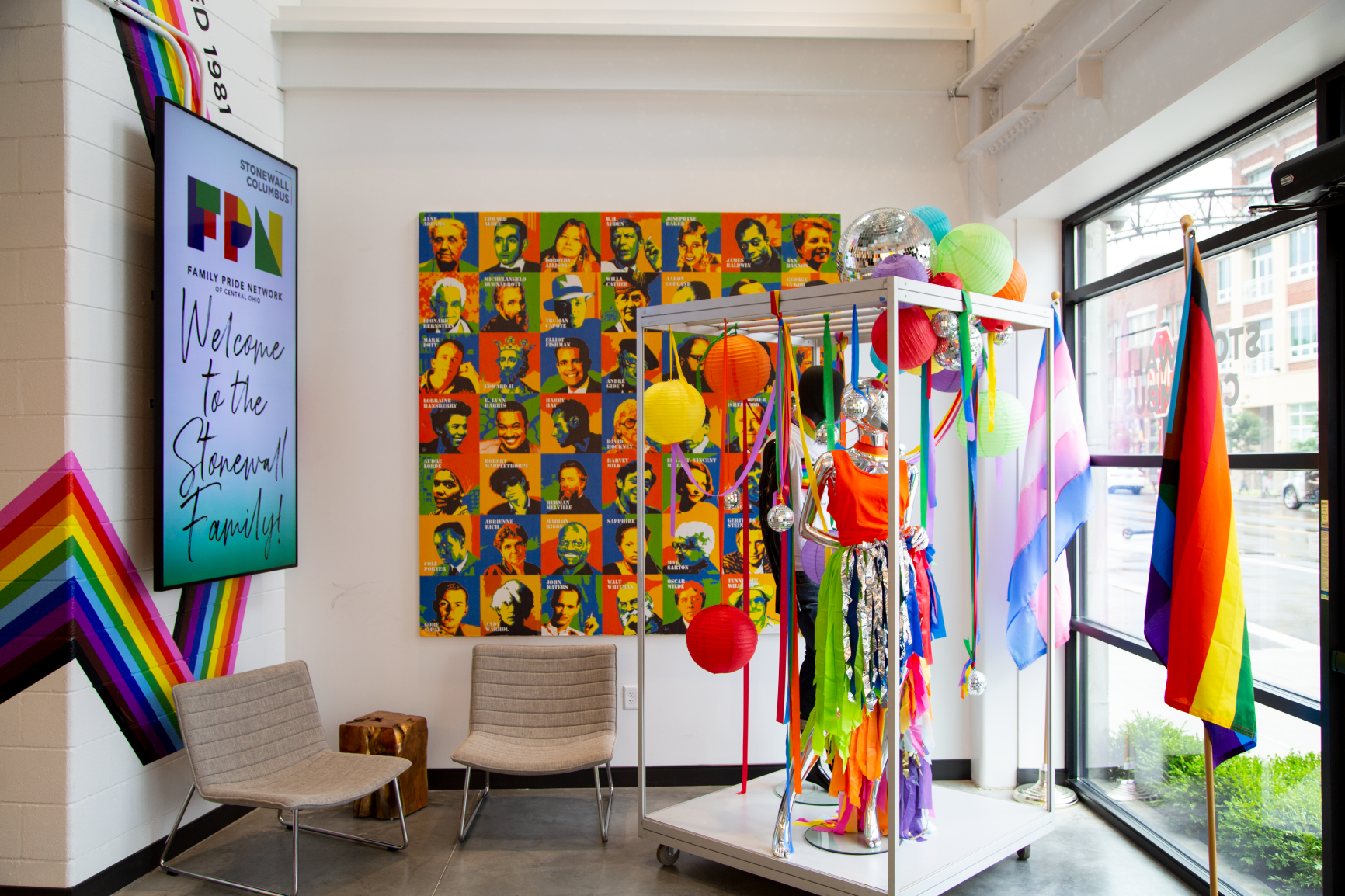 The space features a fashion display along with a collage of influential leaders to showcase important LGBTQ+ history at Stonewall Columbus Continental Office Branding