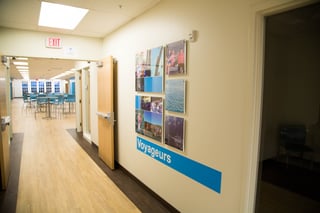 A "Voyageurs" wall features photos of students’ travels